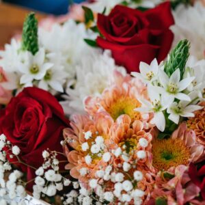 A colorful bouquet featuring red roses, white star of Bethlehem, and chrysanthemums.